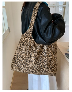 Side view of model wearing a leopard print canvas tote bag with large capacity