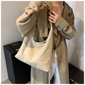 Détail d'un sac hobo en cuir beige montrant une grande capacité et une texture souple