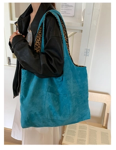 Detail of blue faux suede tote bag featuring contrast leopard print lining and front pocket