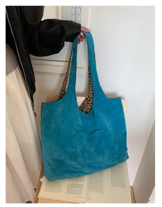 Detail of turquoise corduroy tote bag with leopard print lining and long shoulder straps
