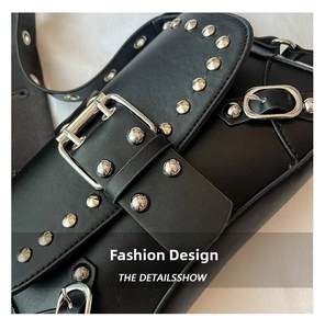 Detailed view of silver rivets and metallic buckle straps on a black punk-style bag