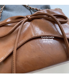 Detail of brown faux leather texture and elegant bow knot decoration on crossbody bag