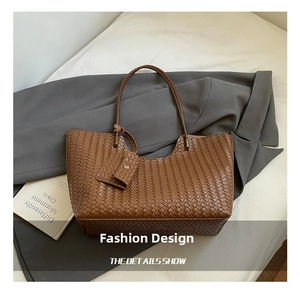 Detail of brown woven tote bag showing leather texture and matching small pouch