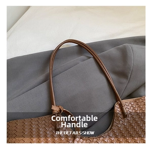 Detail of knotted leather shoulder strap on a brown woven tote bag with refined craftsmanship