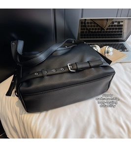 Detail of black lychee leather tote with silver metal eyelets and decorative buckle