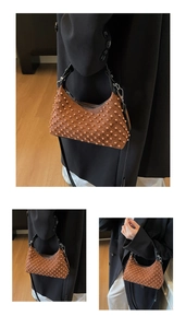 Detail of brown suede tote with diamond stitching and pearl rivet studs on the surface