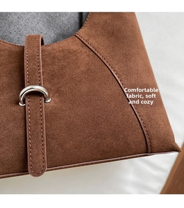 Detail of brown suede material with silver metal ring buckle and neat stitching