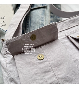 Detail of the hidden magnetic closure on a lavender nylon crossbody shoulder bag