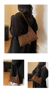 Detail of a brown suede hobo bag with silver buckle and minimalist underarm strap