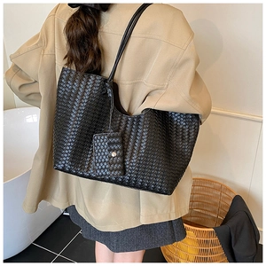 Detail of black woven tote bag with shoulder straps and matching detachable pouch