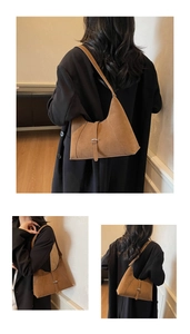 Detail of vintage brown suede shoulder bag showing stitching and metal buckle
