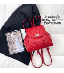 Macro detail of red quilted mini backpack with silver twist lock and diamond stitching