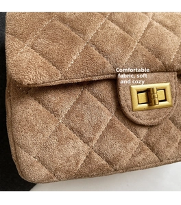 Gros plan sur la texture en daim matelassé marron foncé et le fermoir rotatif doré chic