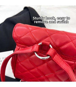 Detail of sturdy silver metal ring hook and detachable red quilted leather strap