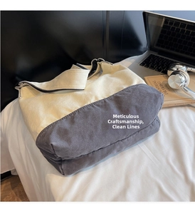 Détail d'un sac en toile bicolore montrant la texture tissée et la boucle de bandoulière réglable