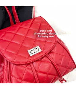 Detail of red quilted backpack showing silver metal turn-lock and drawstring closure
