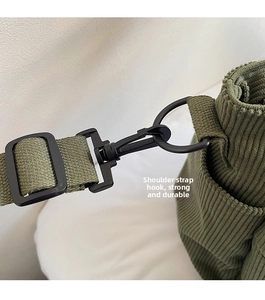 Detail of durable swivel hook and adjustable strap on green corduroy tote bag