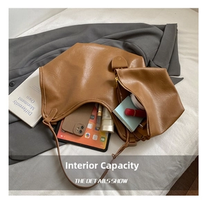 Close-up detail of large capacity brown tote bag showing internal storage items
