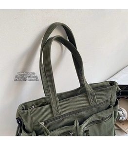 Detail view of large corduroy tote bag with multiple zip pockets and wide shoulder straps