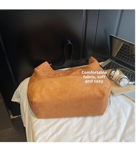 Détail de la texture cuir givré camel foncé et bandoulière large sur grand sac cabas