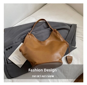 Detail of the vintage brown leather tote showing soft texture and irregular curved top