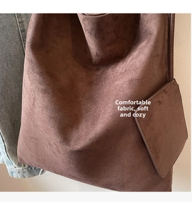 Gros plan du cabas vintage en daim marron montrant la texture douce et la pochette