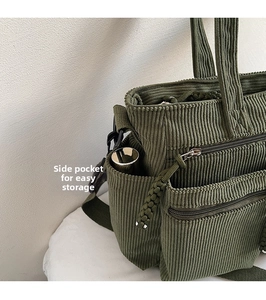 Detail view of corduroy tote bag featuring a side pocket with a metallic water bottle