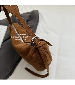 Nahaufnahme der braunen Wildledertasche mit polierten silbernen Metallbeschlägen und Schnalle