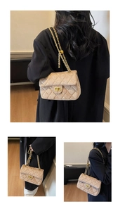 Dettaglio della borsa in velluto trapuntato beige con catena dorata e chiusura quadra