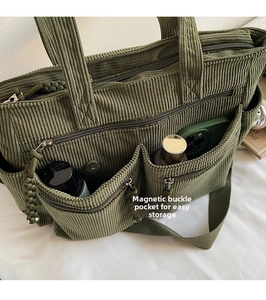 Detail of dark green corduroy tote bag featuring two front magnetic snap pockets for storage
