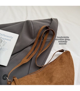 Detail eines braunen Wildleder-Schultergurts und hochwertige Textur einer Hobo-Bag