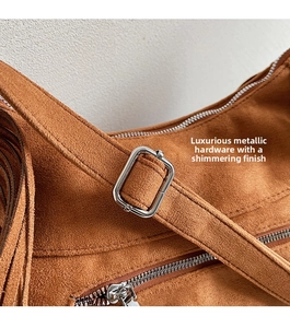 Detail of premium brown suede shoulder bag with high-quality silver metal zipper and buckle