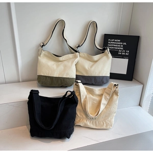 Détail montrant des sacs cabas en toile en quatre couleurs avec de larges bandoulières