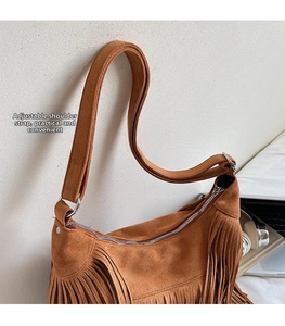 Detail of brown suede fringe bag showing adjustable shoulder strap and silver zipper