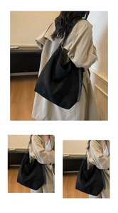 Vue détaillée du grand sac cabas en toile noire avec large bandoulière et boucle argentée
