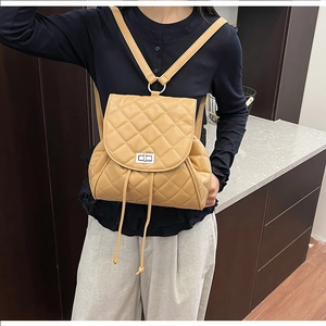 Detailed close-up of yellow quilted leather backpack with silver clasp and drawstring