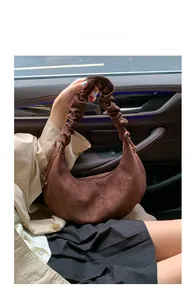 Braune Wildleder-Halbmondtasche mit gerafftem Griff in einer Auto-Innenansicht