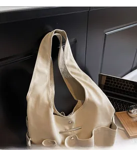 Detail of beige faux leather tote bag with wide straps and functional pocket design