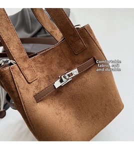 Close-up of brown suede bucket bag featuring silver metal turn-lock and fine texture