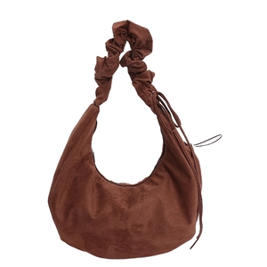 Brown suede hobo bag with pleated shoulder strap and fringe detail on white background