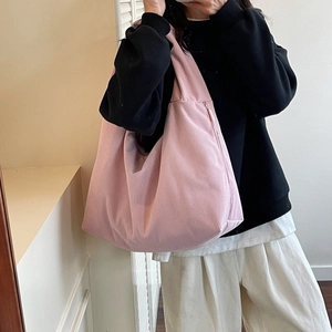 Gros plan sur un sac hobo en velours côtelé rose montrant la texture côtelée et le zip