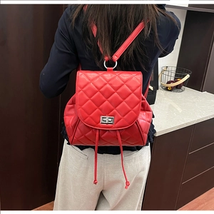 Detail of red quilted leather backpack with silver turn-lock and drawstring closure