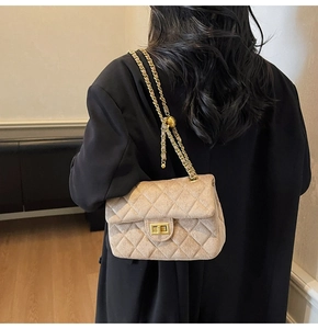 Dettaglio ravvicinato della borsa in pelle scamosciata trapuntata con chiusura dorata