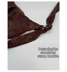 Detail of dark brown suede shoulder bag featuring a stylish knotted strap and silver ring
