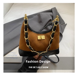 Macro detail of retro quilted leather base and elegant gold twist-lock on a suede shoulder bag