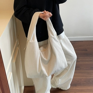 Détail du sac hobo en velours côtelé blanc cassé avec texture rayée et fermeture éclair