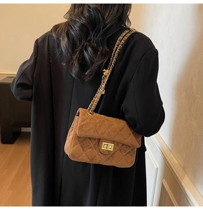 Détail d'un sac à rabat en velours matelassé marron avec fermoir doré et bandoulière