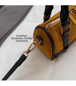 Macro view of vintage bronze hardware and brown suede texture on a Boston bag