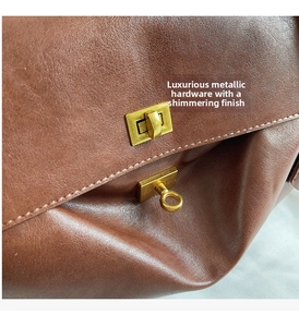 Detail of brown leather tote with vintage golden twist-lock closure and fine stitching