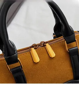 Detail of smooth metal double zippers and suede leopard print texture on Boston bag